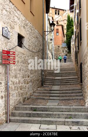 Una coppia che sale i gradini di pietra in un vicolo che conduce Fino al castello di Burgos Castiglia e Leon Spagna Foto Stock