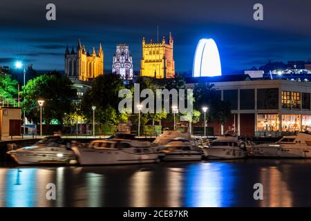 La Cattedrale di Bristol e la Torre Universitaria del Wills Memorial Building sono illuminate di notte sopra il porto galleggiante di Bristol. Foto Stock