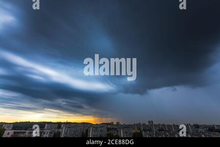 Nuvole tempesta sulla città con la pioggia Foto Stock