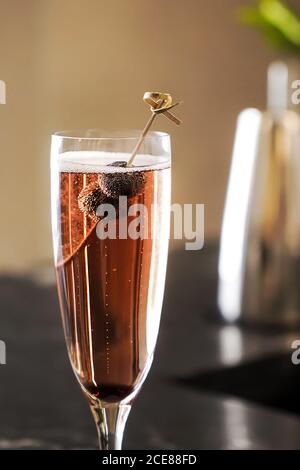 Bicchiere di bevanda frizzante alcolica con mirtilli freschi sullo spiedino Foto Stock