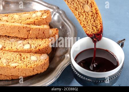 Biscotti, biscotti tradizionali italiani alle mandorle, immersi in una tazza di cioccolata calda Foto Stock