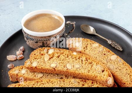 Cantuccini, biscotti tradizionali italiani alle mandorle, con una tazza di caffè Foto Stock