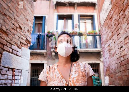 Giovane turista che indossa la maschera a piedi in una strada di Venezia in Italia. Viaggi e turismo industria durante la pandemia del virus della corona e covid19 di Foto Stock