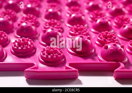 Tappetino ortopedico per agopuntura rosa. Tappetino massaggiante per la prevenzione dei piedi piani in bambini e adulti Foto Stock