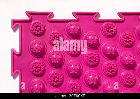 Tappetino ortopedico per agopuntura rosa. Tappetino massaggiante per la prevenzione dei piedi piani in bambini e adulti. Foto Stock