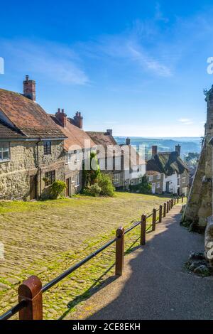 Guardando giù per la storica e acciottolata Gold Hill alla fila di cottage a Shaftesbury, Dorset, Inghilterra, Regno Unito Foto Stock