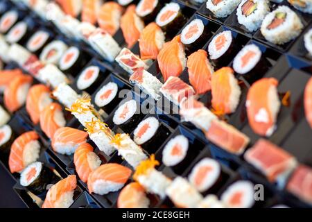 Alto angolo di sushi e panini assortiti e appetitoso contenitori in plastica in negozio Foto Stock