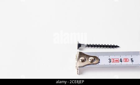 Metro a nastro di roulette e auto-taglio su sfondo bianco. Banner degli strumenti di costruzione con spazio per il testo. Foto Stock
