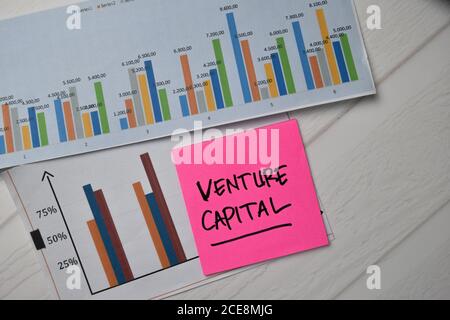 Venture Capital scrivere su note appiccicose con grafica sulla carta isolata sulla scrivania dell'ufficio. Foto Stock