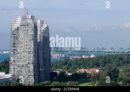 Singapore, riflessioni a Keppel Bay, lussuoso complesso residenziale con vista dal Monte Faber. Sullo sfondo, l'area industriale e portuale Foto Stock