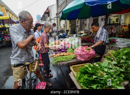 Georgetown, Penang/Malaysia - Giu 17 2016: La gente compra le verdure al mercato umido in strada. Foto Stock