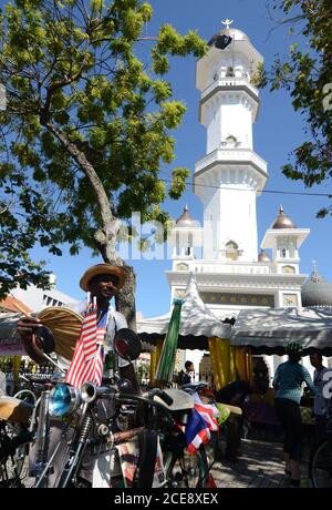 Georgetown, Penang/Malaysia - Luglio 30 2016: Un uomo con un vecchio parco per biciclette di fronte a Masjid Kapitan Keling. Foto Stock