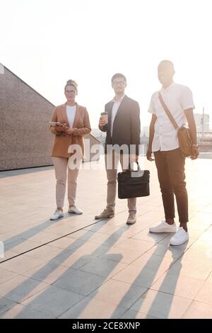 Ritratto di contenuti sicuri giovani professionisti multietnici in piedi luce solare all'aperto Foto Stock