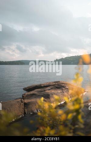 Spiaggia pietrosa vicino lago calmo in nuvoloso giorno estivo in Algonquin Provincial Park in Canada Foto Stock