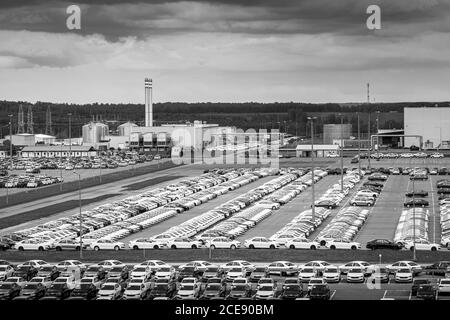 Volkswagen Group Rus, Russia, Kaluga - 24 MAGGIO 2020: File di auto nuove parcheggiate in un centro di distribuzione in un giorno e edifici di una fabbrica di automobili. Parcheggio Foto Stock