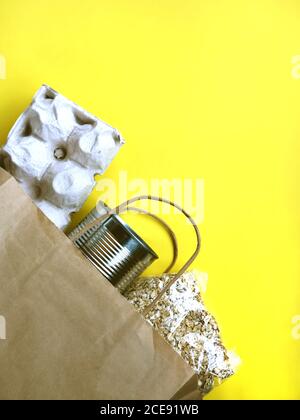 Cibo: Uova, cibo in scatola e avena groat su sfondo giallo Foto Stock