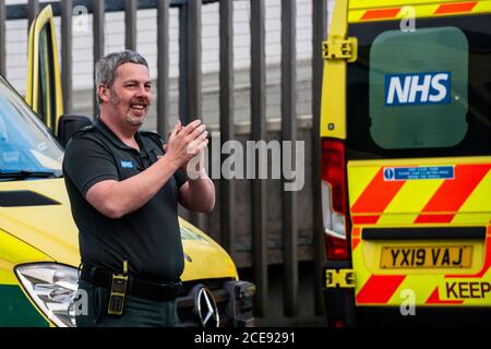 Un paramedico che si aggrappò all'esterno dell'ospedale Harrogate mentre partecipa a Clap per i nostri caregisti. Foto Stock