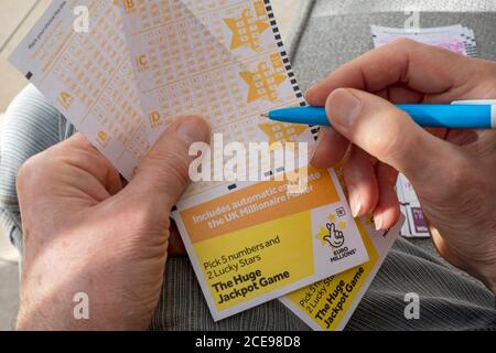 Primo piano di un uomo che compila il modulo lotteria lotteria EuroMillions Lotto. Foto Stock