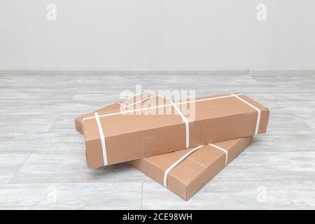 In un appartamento sono confezionate scatole con mobili sul pavimento. Parti di assemblaggio di mobili in scatole imballate. Consegna pacchi. Foto Stock