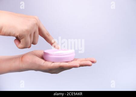 donna che applica la crema di bellezza sulla pelle isolata in bianco Foto Stock