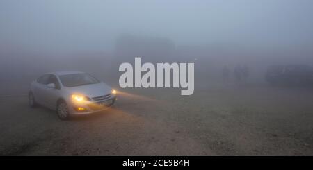 fagaras, romania - 26 GIU 2017: Auto nella nebbia sulla strada transfagarasan 7C. Bassa visibilità, fari non aiutano. Condizioni atmosferiche drammatiche Foto Stock