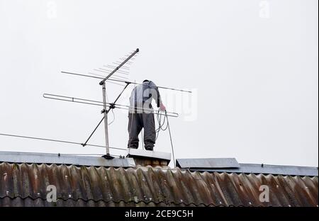 La scopa per camino elimina cenere e fuliggine dai camini il giorno nuvoloso dell'autunno. Foto Stock