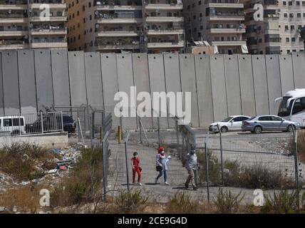 Campo profughi di Shurafat, Israele. 31 Agosto 2020. I palestinesi camminano attraverso la recinzione di sicurezza israeliana vicino al muro di separazione intorno al campo profughi di Shurafat vicino a Gerusalemme, lunedì 31 agosto 2020. Il consigliere presidenziale degli Stati Uniti, Jared Kushner, ha invitato i palestinesi a ritornare ai negoziati con Israele e non ad essere 'stuck in passato' all'arrivo ALL'AUE durante il primo volo diretto da Israele ad Abu Dhabi. Foto di Debbie Hill/UPI Credit: UPI/Alamy Live News Foto Stock