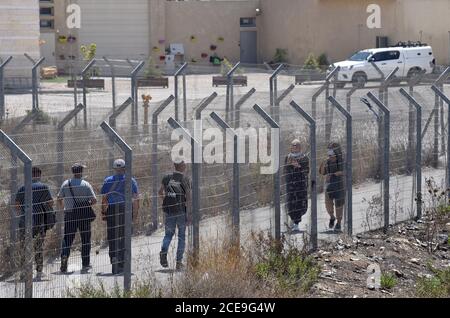 Campo profughi di Shurafat, Israele. 31 Agosto 2020. I palestinesi camminano attraverso la recinzione di sicurezza israeliana vicino al muro di separazione intorno al campo profughi di Shurafat vicino a Gerusalemme, lunedì 31 agosto 2020. Il consigliere presidenziale degli Stati Uniti, Jared Kushner, ha invitato i palestinesi a ritornare ai negoziati con Israele e non ad essere 'stuck in passato' all'arrivo ALL'AUE durante il primo volo diretto da Israele ad Abu Dhabi. Foto di Debbie Hill/UPI Credit: UPI/Alamy Live News Foto Stock