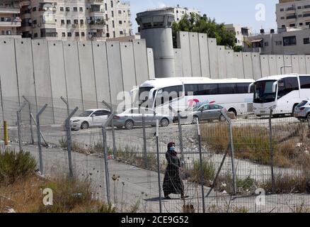 Campo profughi di Shurafat, Israele. 31 Agosto 2020. Un palestinese cammina attraverso la recinzione di sicurezza israeliana vicino al muro di separazione intorno al campo profughi di Shurafat vicino a Gerusalemme, lunedì 31 agosto 2020. Il consigliere presidenziale degli Stati Uniti, Jared Kushner, ha invitato i palestinesi a ritornare ai negoziati con Israele e non ad essere 'stuck in passato' all'arrivo ALL'AUE durante il primo volo diretto da Israele ad Abu Dhabi. Foto di Debbie Hill/UPI Credit: UPI/Alamy Live News Foto Stock