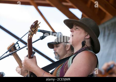 Sally Newsome-Ladd, accompagnato da John Cotton alla chitarra, guida la Sol Mountain Band in una fiera di Winninghoff Park a Philipsburg, Montana, domenica, Foto Stock