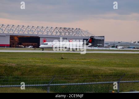 montreal, Quebec / Canada - 07/02-2020 : Air Canada Express (Jazz) CRJ900 atterra all'aeroporto internazionale di Montreals in una serata nuvolosa. Foto Stock