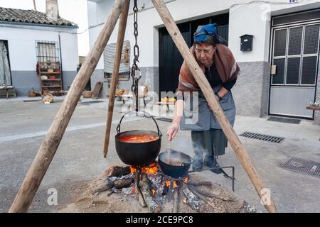 VALDASTILLAS, SPAGNA - 23 novembre 2019: Festa di rappresentazione della macellazione del maiale con musica tradizionale, mercato e arrosto di braciole sulla barbe Foto Stock