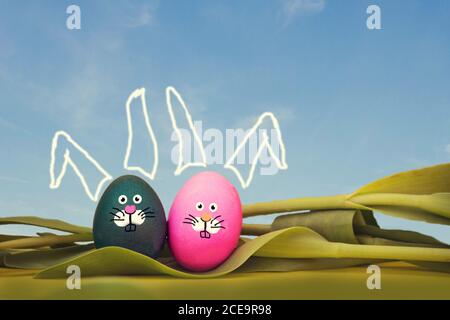 Dipinto di uova di pasqua con bunny faccia e cielo blu, giacente in tulipani, pasqua concetto a molla Foto Stock