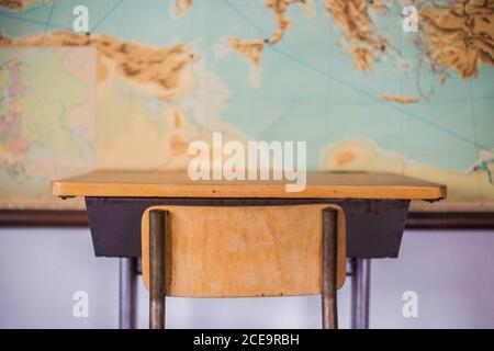 Banchi vuoti in aula scolastica con mappa del mondo. Foto Stock