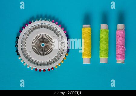 sistema di posa piatto per cucire con cotone e spille su a. sfondo blu Foto Stock