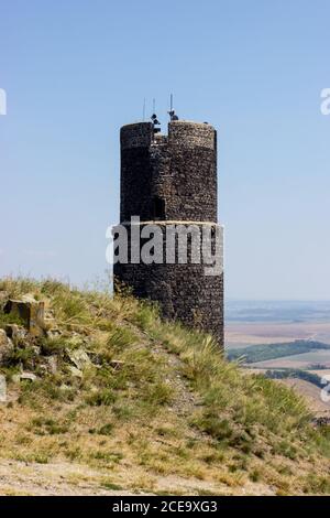 Ruines del castello di Hazmburk in cima alla cima della catena montuosa di ceske stredohori. Vista sulla torre nera. Foto Stock