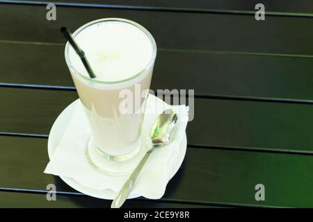 Un delizioso frullato freddo su fondo di legno nero. Foto Stock