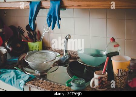Tavolo disordinato con piatti sporchi nel lavandino della cucina. Foto Stock