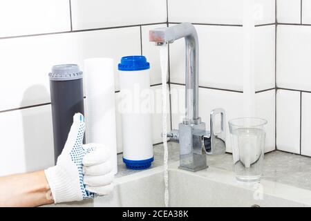 Sostituzione dei filtri nel sistema di purificazione dell'acqua. Vista ravvicinata di tre nuovi filtri. Acqua pulita a casa. Pollici in su Foto Stock