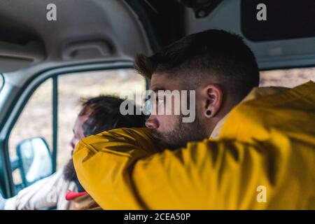 Due uomini seduti in un bel pulmino e guardando la strada mentre si viaggia attraverso l'Islanda insieme. Foto Stock