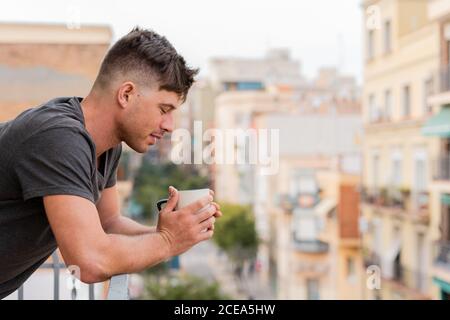 Uomo rilassante con caffè sul balcone Foto Stock