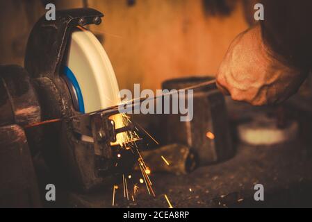 Crop smith con mola per affilare la lama in metallo in modo professionale officina Foto Stock