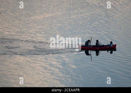 Austin, TX 18 agosto 2020: Tre persone in canoa godersi il tramonto sul lago Lady Bird nel centro di Austin alla fine di una calda giornata estiva. Foto Stock