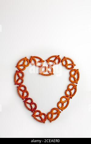 Pretzel a forma di cuore su sfondo bianco Foto Stock