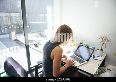 donna che lavora in un ufficio moderno e soleggiato Foto Stock