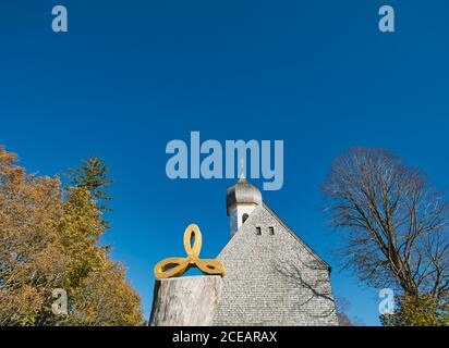 Una facciata di una piccola chiesa coperta di tegole di legno Foto Stock