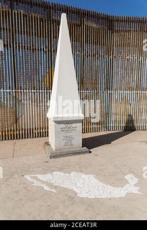 Questo monumento segna il limite settentrionale del paese del Messico, a Tijuana. Dietro di essa si trova la recinzione che segna il confine internazionale tra gli Stati Uniti Foto Stock