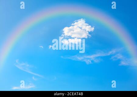 arcobaleno estivo sul cielo blu Foto Stock