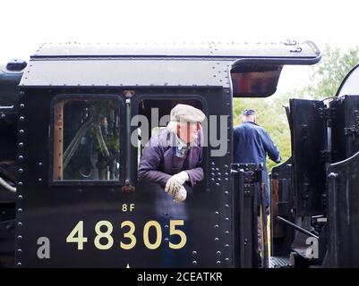 Il conducente si è inclinato fuori dalla cabina di 48395, una locomotiva a vapore Stanier LMS 8F Classe 2-8-0 Foto Stock