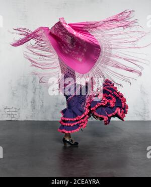 Ballerina di flamenco in azione con il tipico costume da ballo spagnolo. Velocità e movimento elevati. Foto Stock